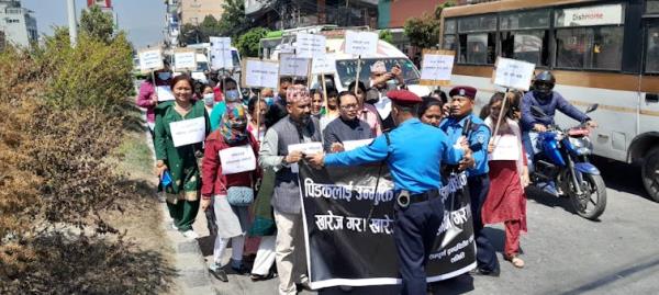 A group of men and woman holding placards walk down a street